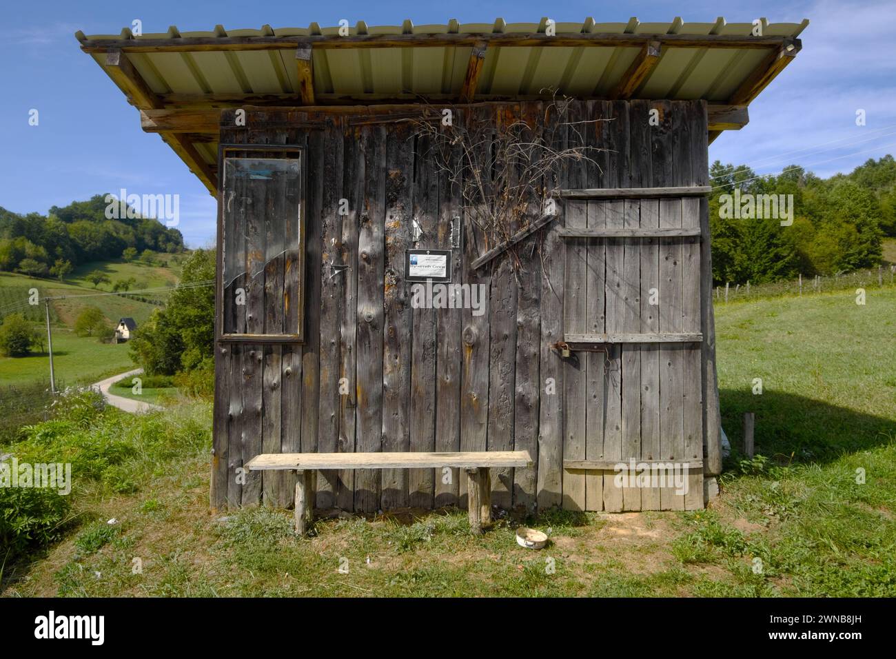 Vecchia baracca di legno con un piccolo annuncio funerario di carta bianca e nera vicino a Ivanjica in Serbia Foto Stock