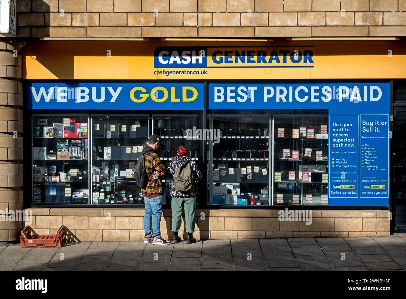 Giovane coppia che guarda alla finestra di Cash Generator, un negozio Buy and sell su Dalry Road, Edimburgo, Scozia, Regno Unito. Foto Stock