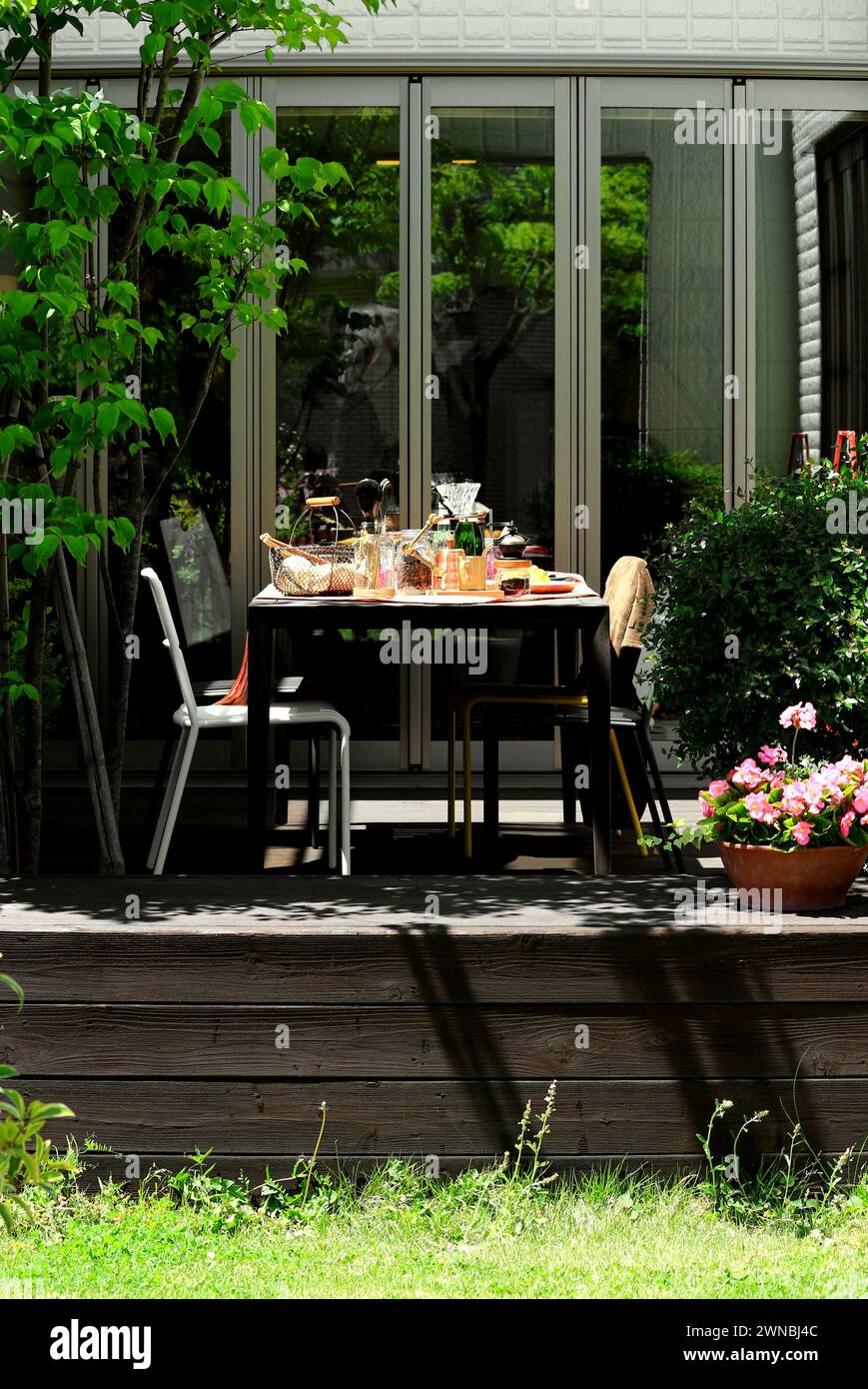 Tavolo da pranzo sulla terrazza soleggiata pronto per il pranzo Foto Stock