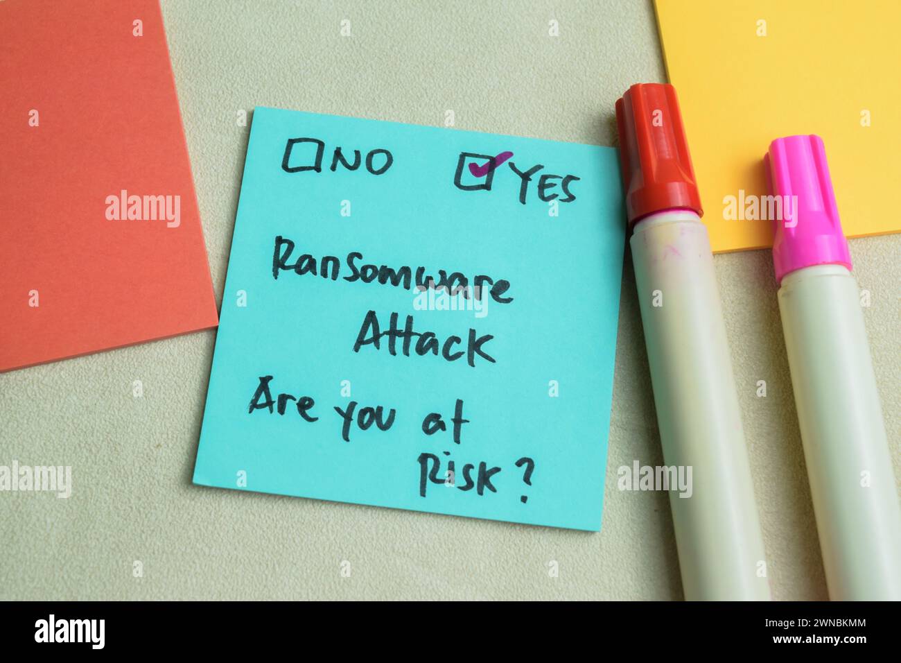 Concetto di attacco Ransomware, sei a rischio? Scrivere su appunti adesivi isolati su un tavolo di legno. Foto Stock