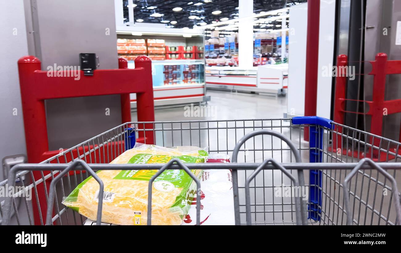 Carrello della spesa pieno di prodotti essenziali presso il Sam's Club Cold Storage area Foto Stock