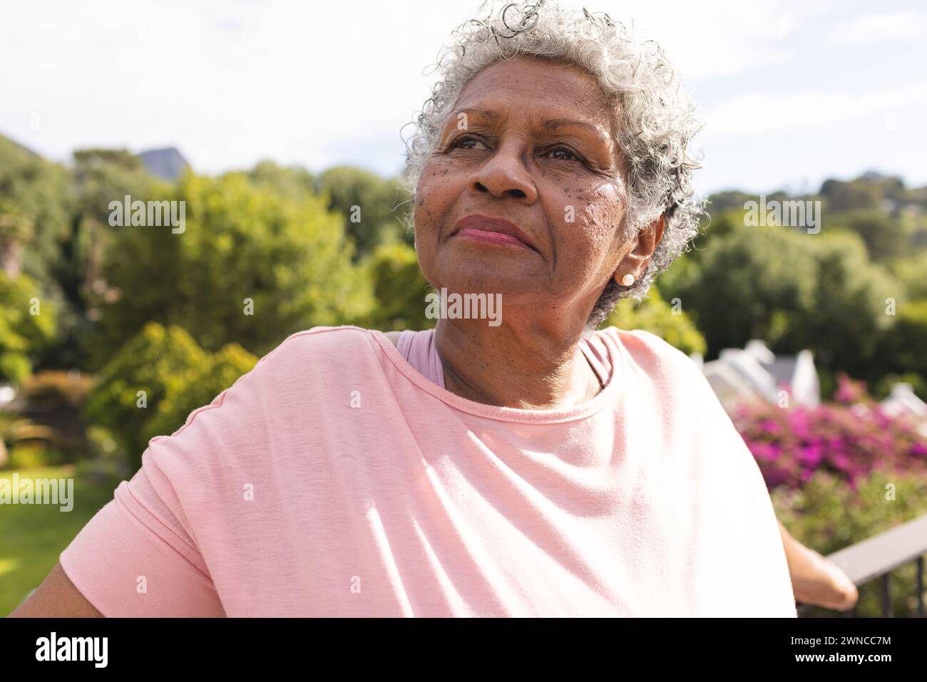 Donna birazziale senior con capelli corti grigi che guarda con cura in un ambiente all'aperto Foto Stock