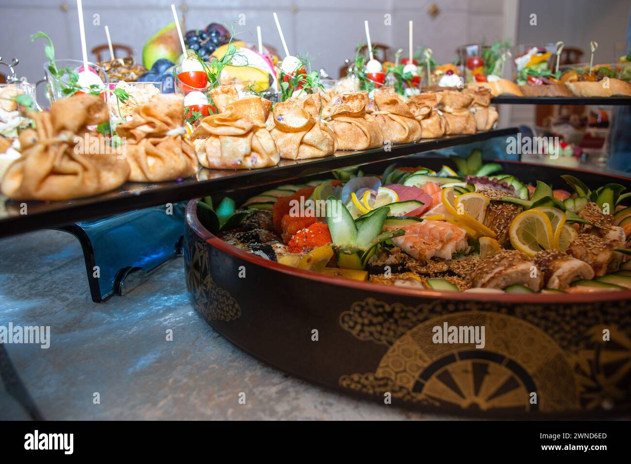 Un sontuoso buffet che offre un ricco assortimento di pesce fresco, sushi, insalate, frutta e pasticcini, splendidamente disposto su un tavolo bianco immacolato Foto Stock