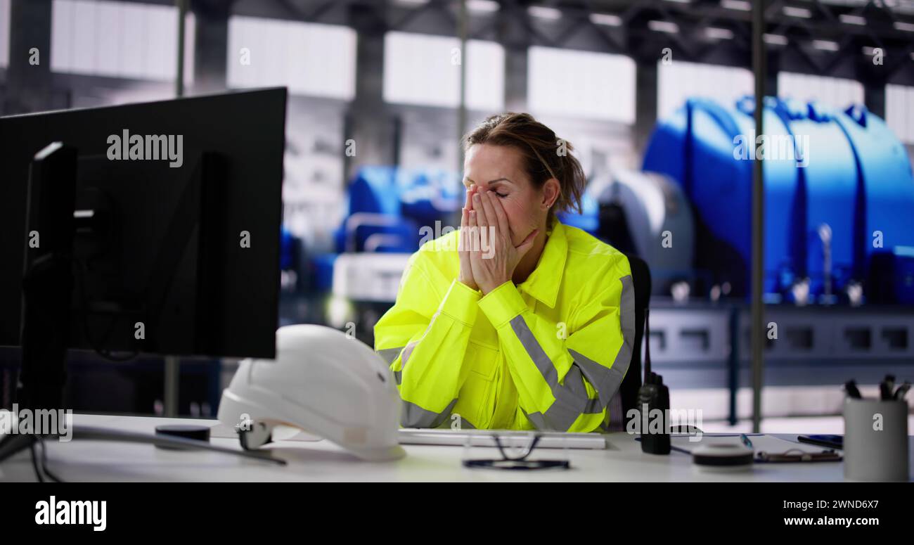 Infelice donna stanca che lavora nella generazione di energia elettrica delle centrali elettriche Foto Stock