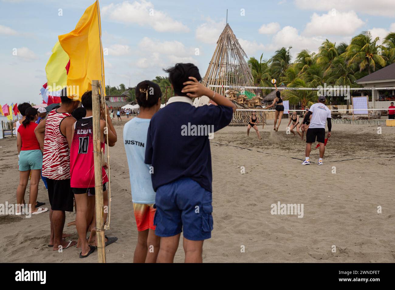 Iloilo City, Filippine. 2 marzo 2024. Gli appassionati di Beach volley assistono a una partita competitiva di Beach volley come parte della celebrazione del Paraw Regatta Festival a Iloilo City, Filippine. Il Paraw Regatta Festival è il più antico evento di artigianato tradizionale in Asia e ha come principale evento una gara di barche a vela, che lo rende il più grande evento velico delle Filippine. Credito: SOPA Images Limited/Alamy Live News Foto Stock