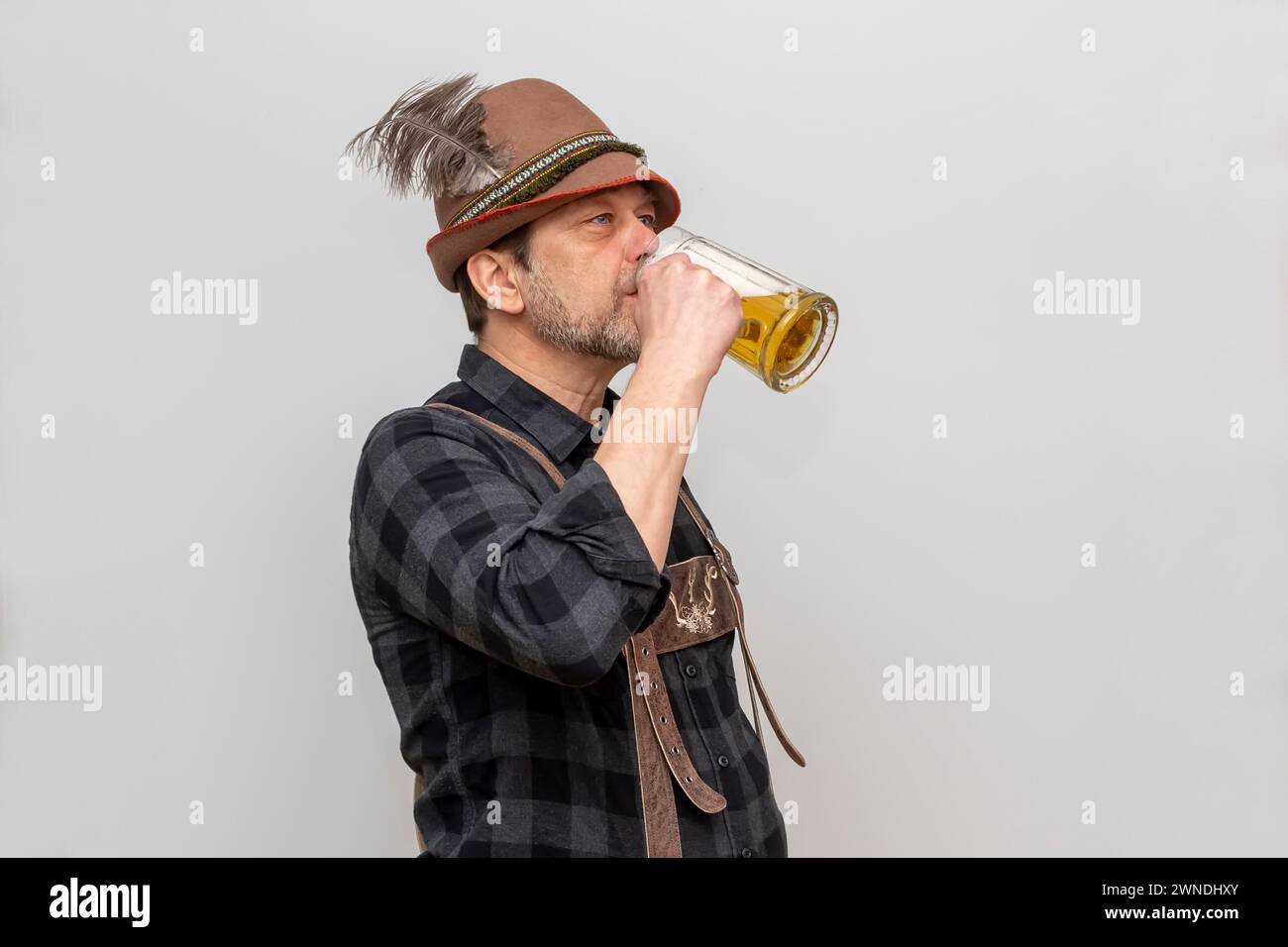 L'anziano barbuto in cappello vuole bere un bicchiere di birra con la schiuma, festival della birra in Austria e Germania. Foto Stock