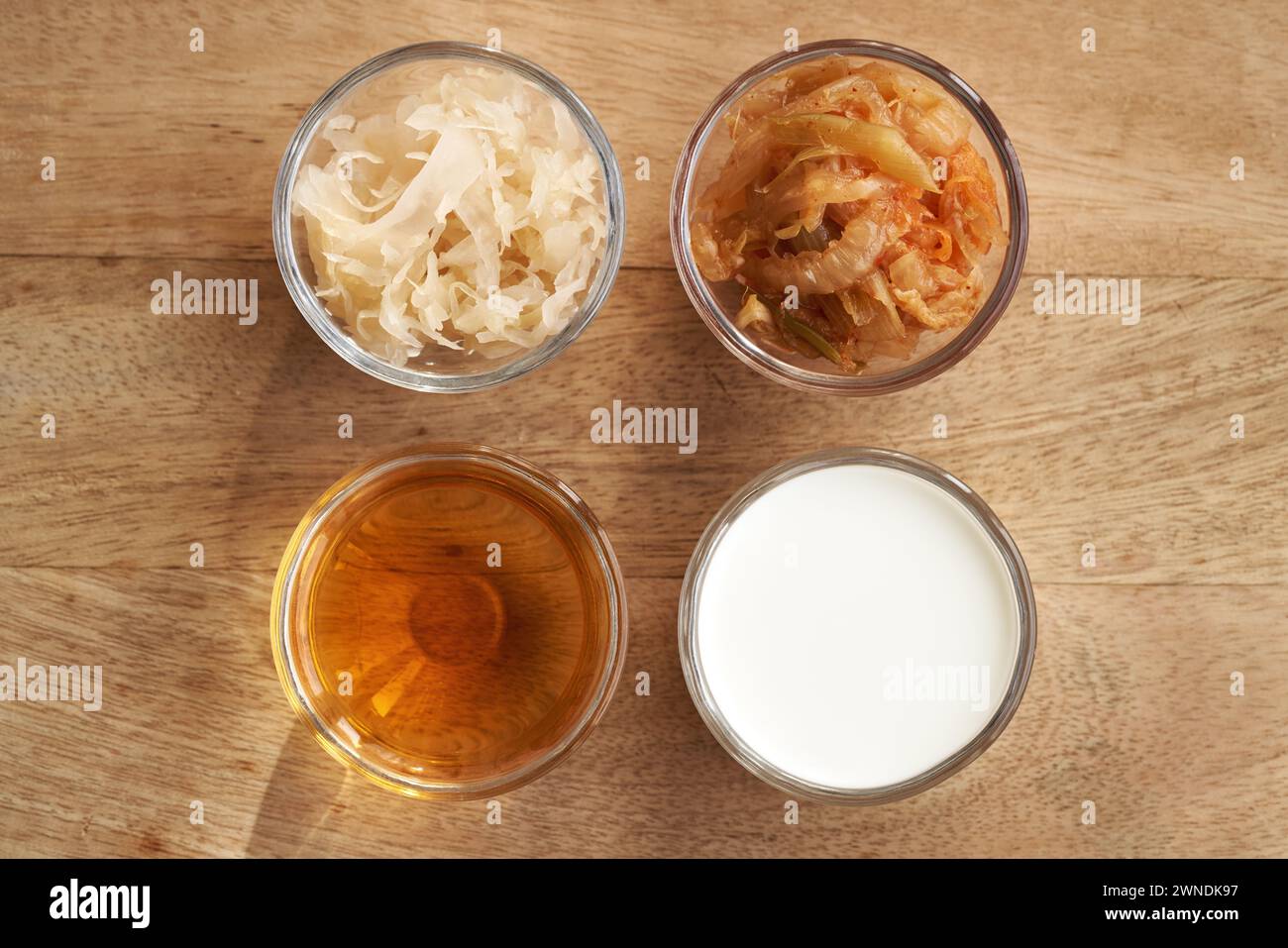 Cibi fermentati in ciotole di vetro - kimchi, crauti, aceto di sidro di mele e kefir, vista dall'alto Foto Stock