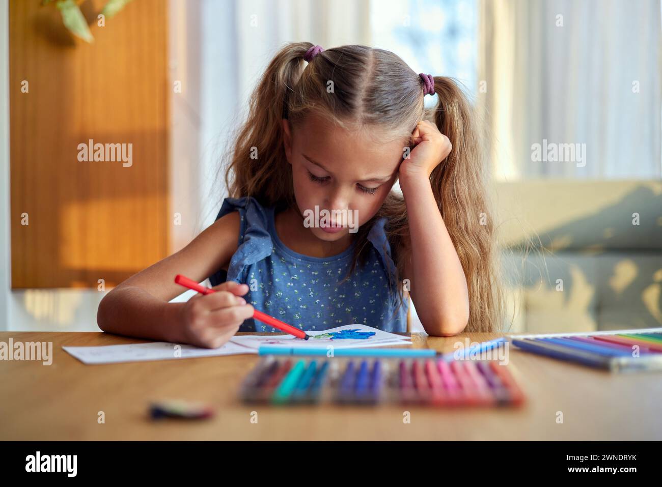 Ragazza concentrata che dipinge con matite colorate Foto Stock