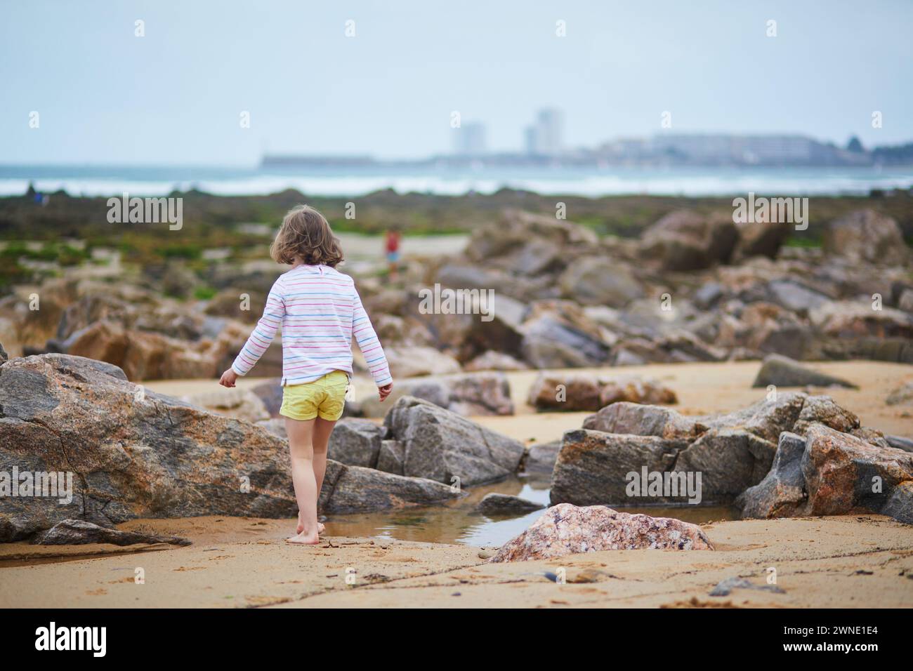 Adorabile bambina in età prescolare che gioca sulla spiaggia della costa atlantica della Bretagna, in Francia. Bambini piccoli che si divertono in vacanza al mare o all'oceano. Viaggiando con wi Foto Stock