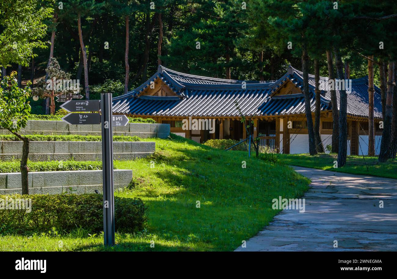 Bagni pubblici in un edificio orientale in legno con tetto piastrellato nell'area ombreggiata del Tempio Neungsa Baekje in Corea del Sud Foto Stock