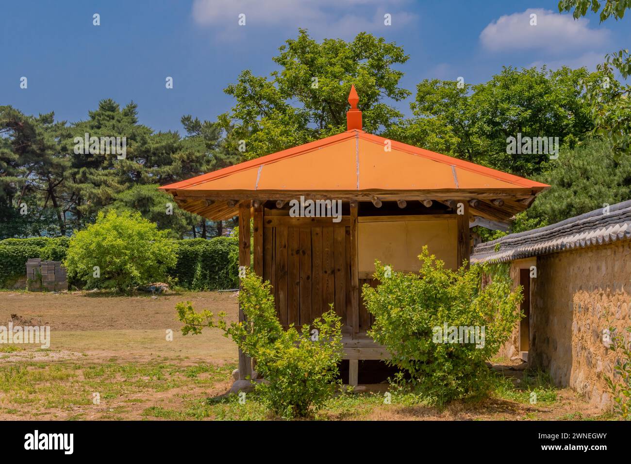 Attico in vecchio stile coreano con tetto arancione con posti a sedere accanto alle pareti orientali nelle giornate di sole della Corea del Sud Foto Stock