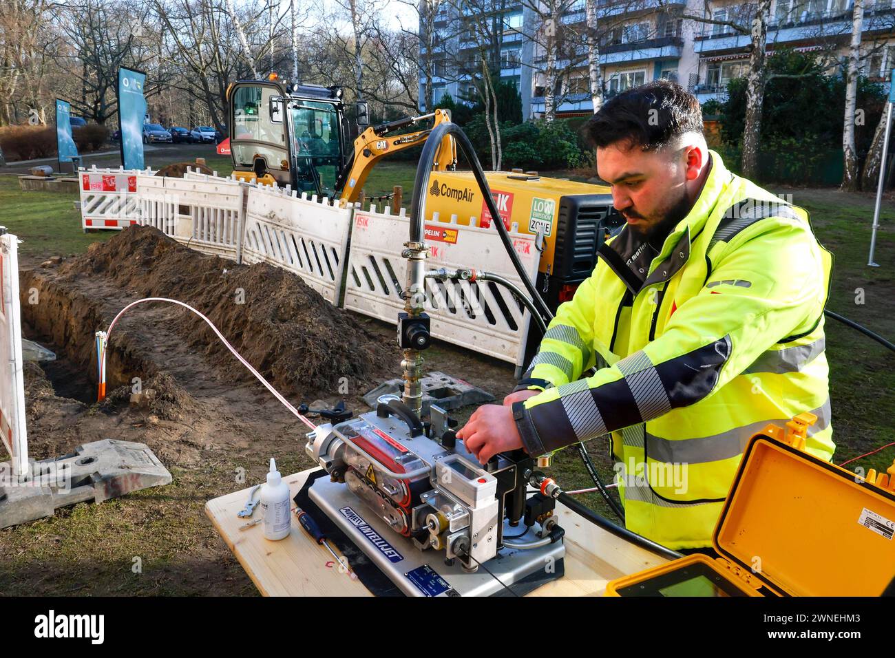 Un lavoratore posa un cavo in fibra di vetro, Berlino, 29/02/2024 Foto Stock