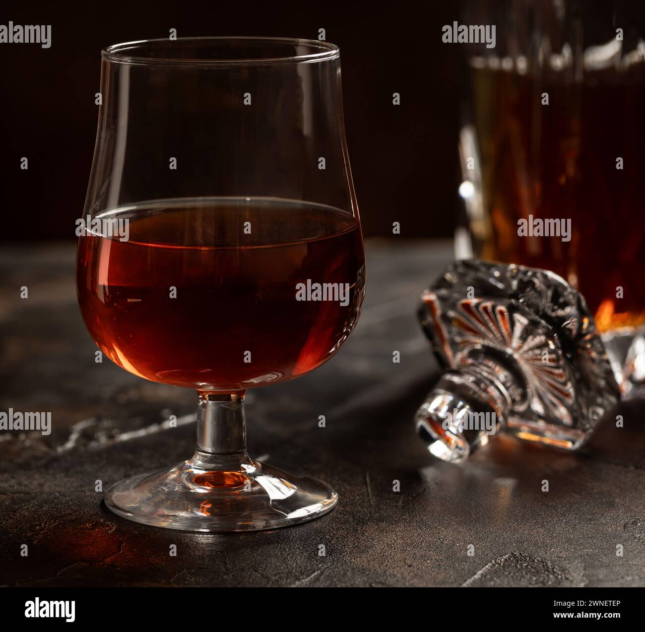 Primo piano di cecchino di brandy e decanter su fondo di legno Foto Stock