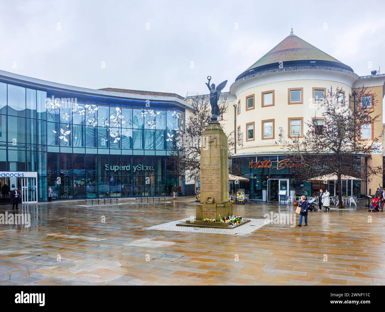 Jubilee Square, memoriale di guerra e ingresso al centro commerciale Peacocks in Victoria Place nel centro di Woking, Surrey, in una giornata noiosa e umida Foto Stock
