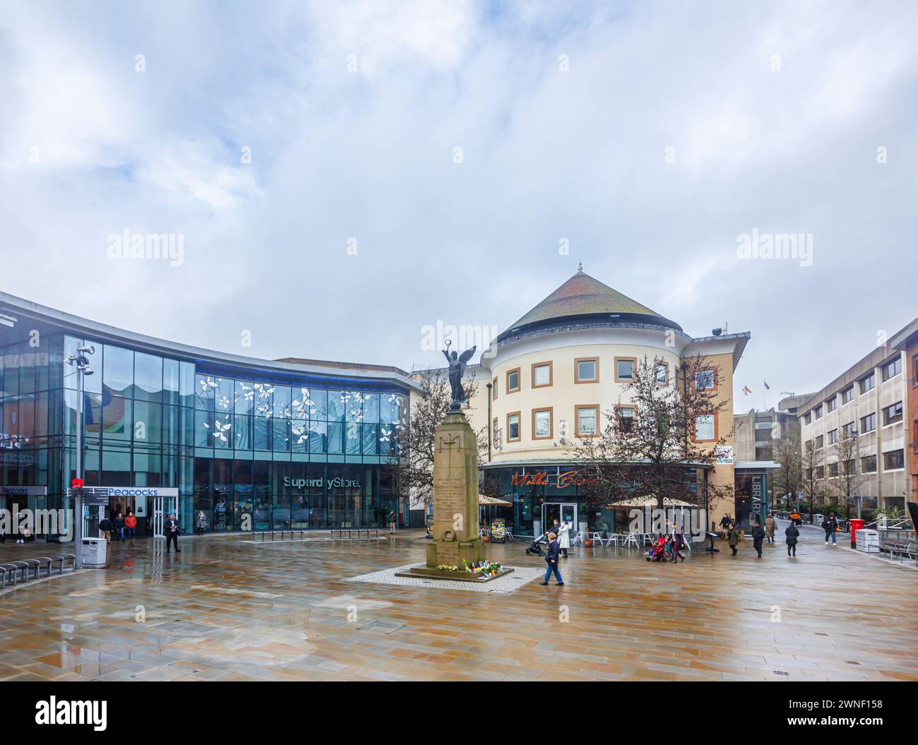 Jubilee Square, memoriale di guerra e ingresso al centro commerciale Peacocks in Victoria Place nel centro di Woking, Surrey, in una giornata noiosa e umida Foto Stock