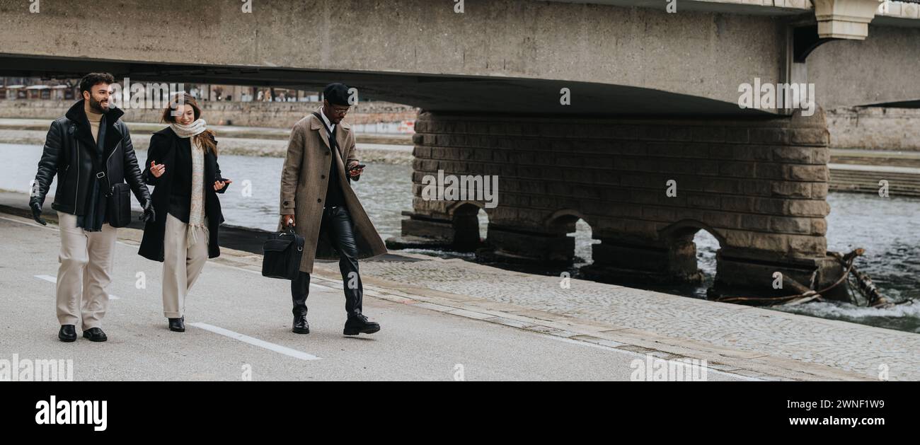 Giovani, multiculturali, soci d'affari che si godono una passeggiata urbana informale nella stagione invernale. Foto Stock