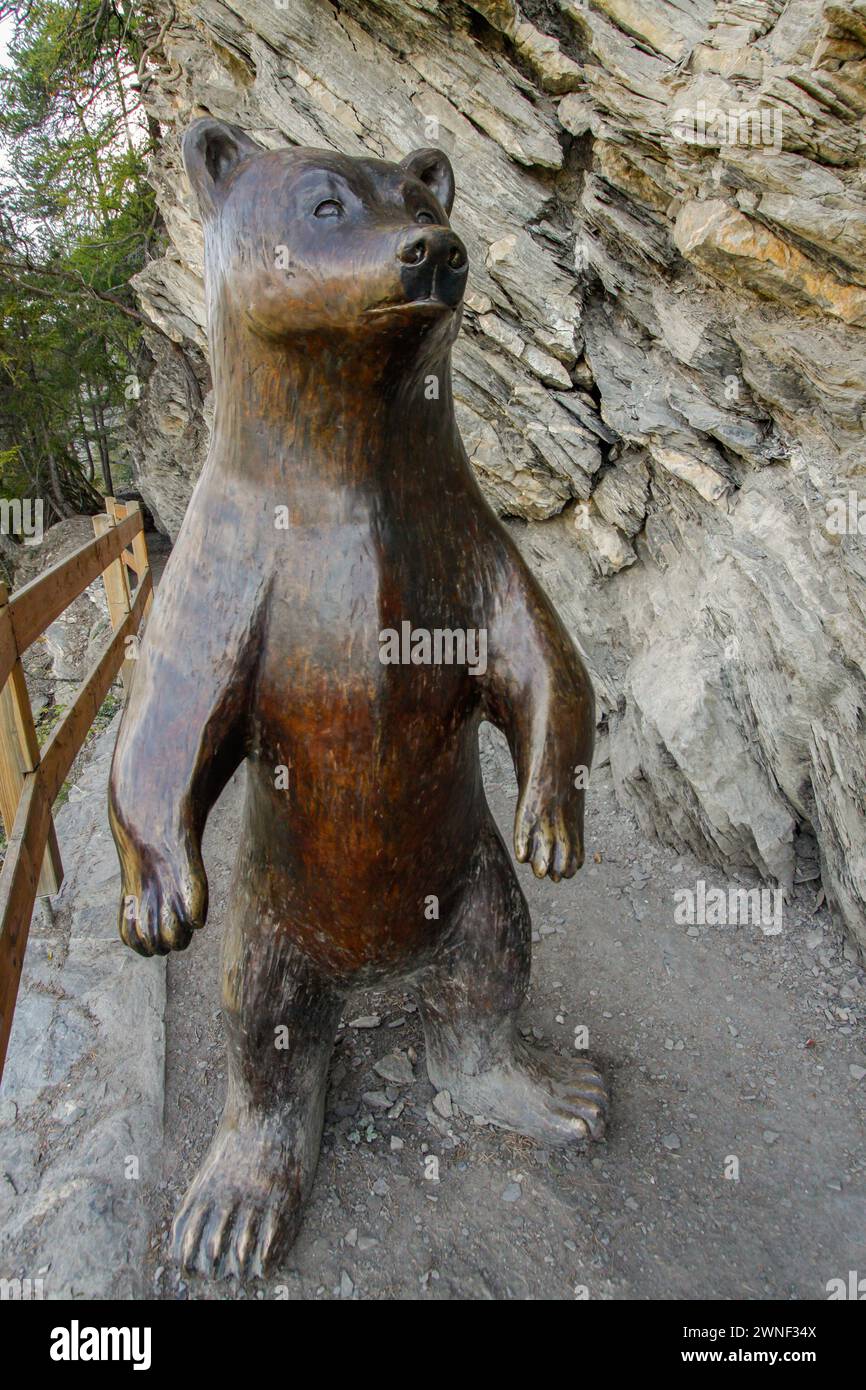 Scultura in legno dell'orso bruno su un sentiero escursionistico di montagna, Canton Vallese, Svizzera Foto Stock