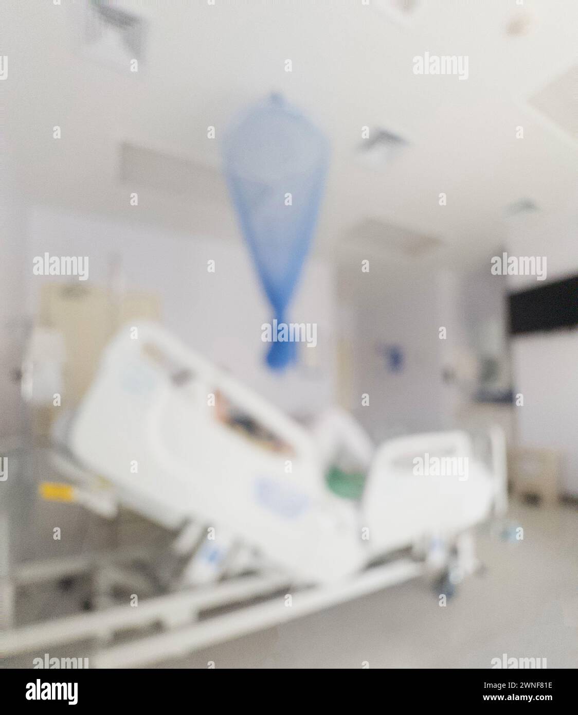 Camera da letto clinica sfocata con paziente collegato a IV Foto Stock