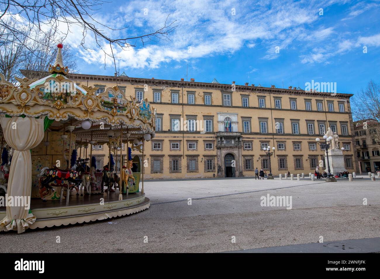 Colorata giostra di fronte al Palazzo Ducale in Piazza Napoleone nel centro storico della città medievale di Lucca, Italia Foto Stock