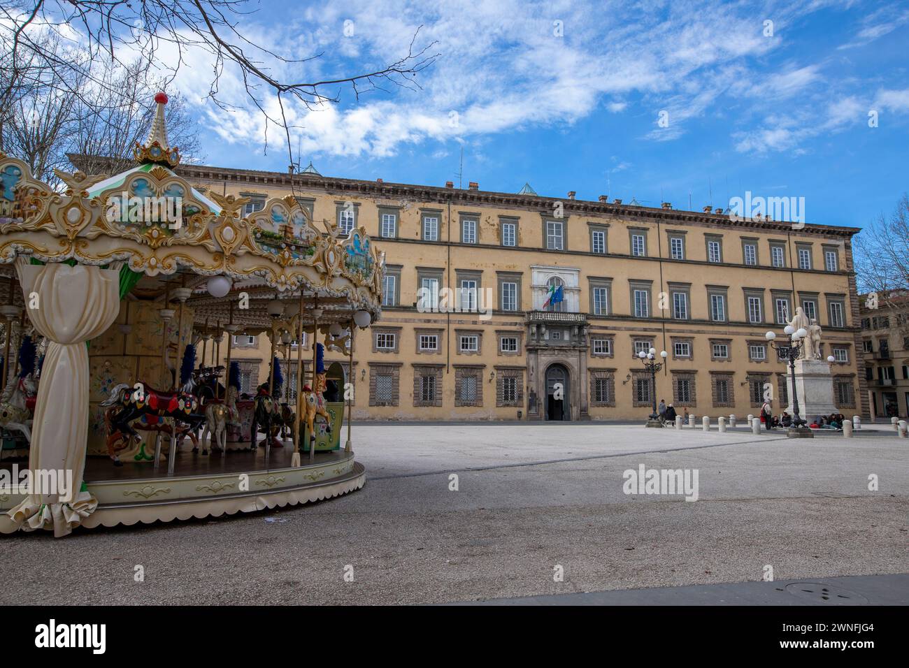 Colorata giostra di fronte al Palazzo Ducale in Piazza Napoleone nel centro storico della città medievale di Lucca, Italia Foto Stock