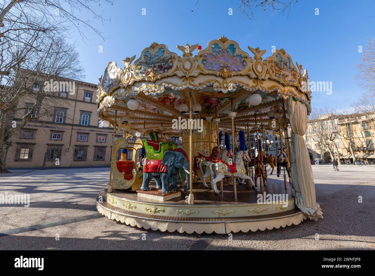 Colorata giostra di fronte al Palazzo Ducale in Piazza Napoleone nel centro storico della città medievale di Lucca, Italia Foto Stock