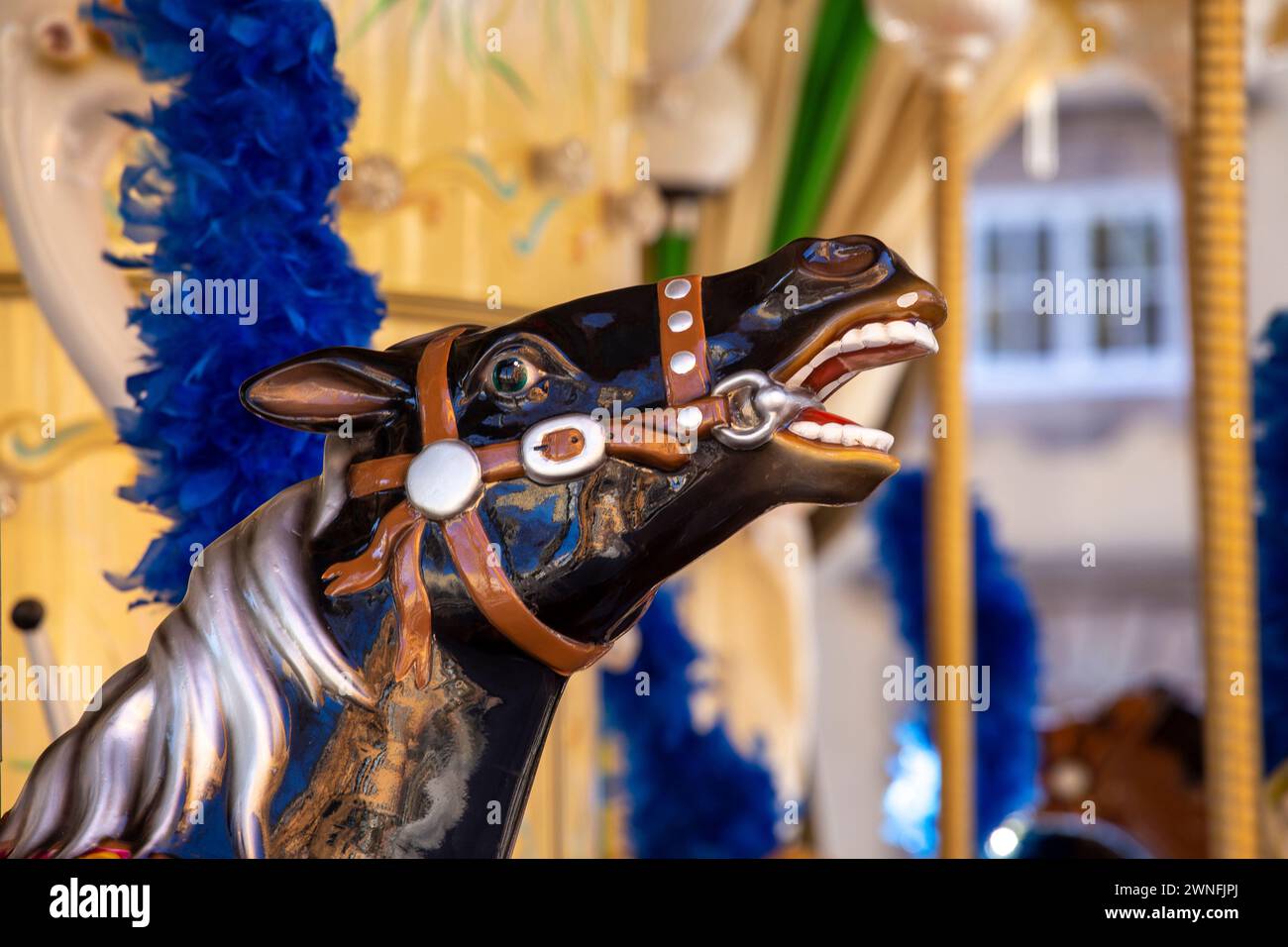 Primo piano di una testa di cavallo nero su una giostra del parco divertimenti a Lucca, Italia Foto Stock