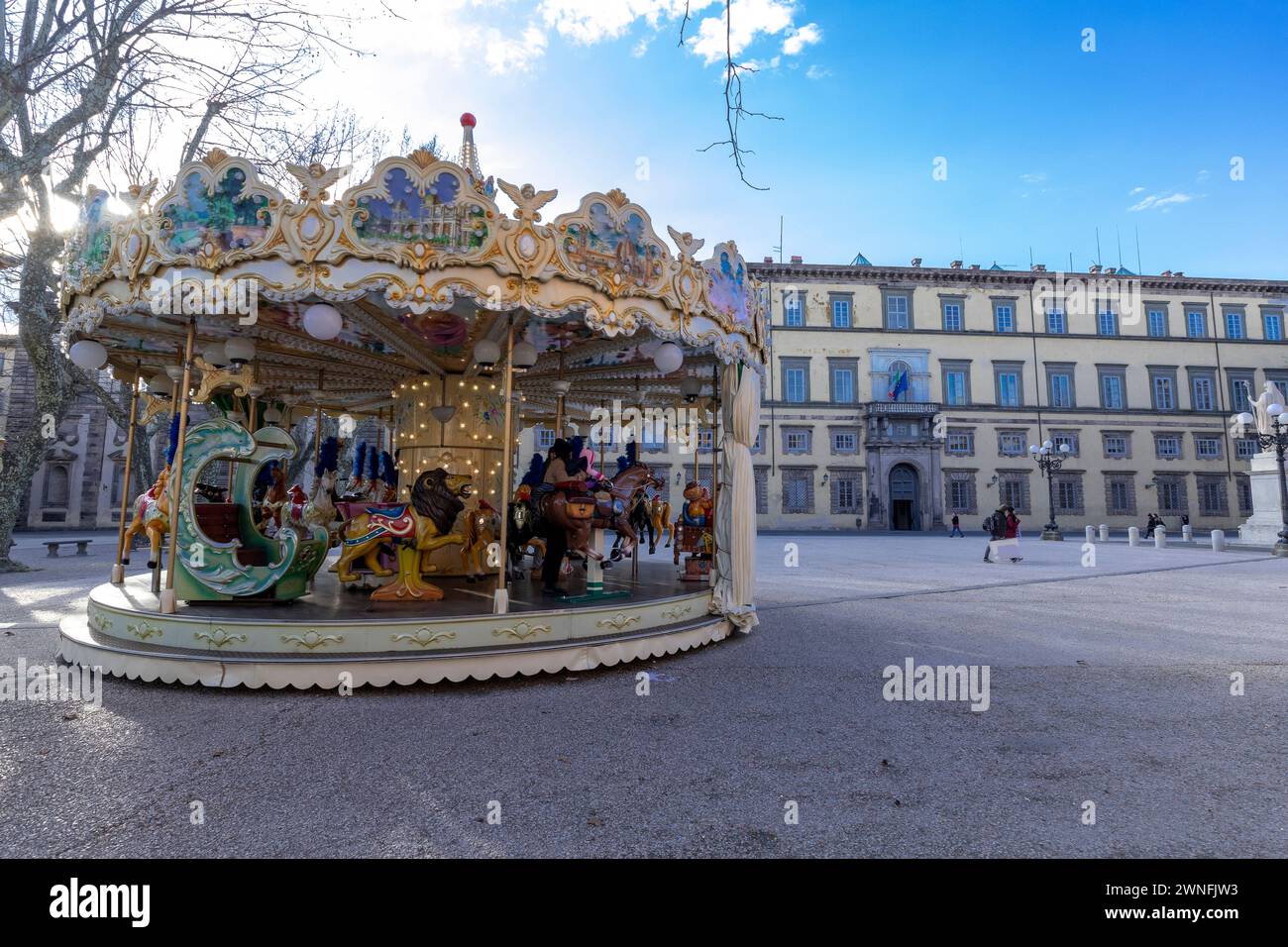 Colorata giostra di fronte al Palazzo Ducale in Piazza Napoleone nel centro storico della città medievale di Lucca, Italia Foto Stock