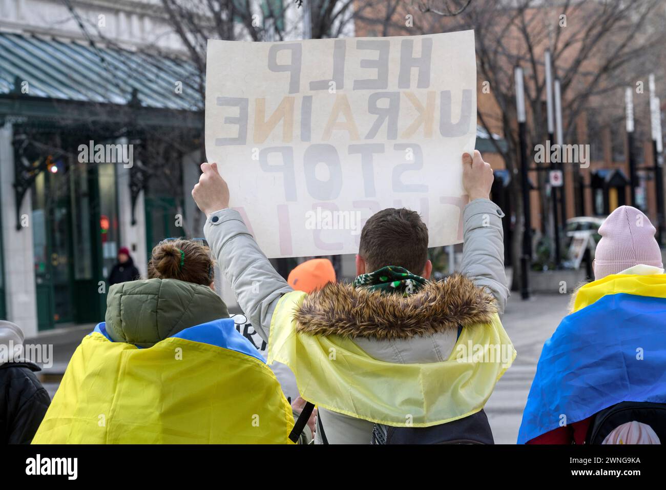 Ucraini alla piazza municipale di Calgary, con un cartello, segnano due anni dall'inizio della guerra. 24 febbraio 2024, Alberta, Canada. Foto Stock