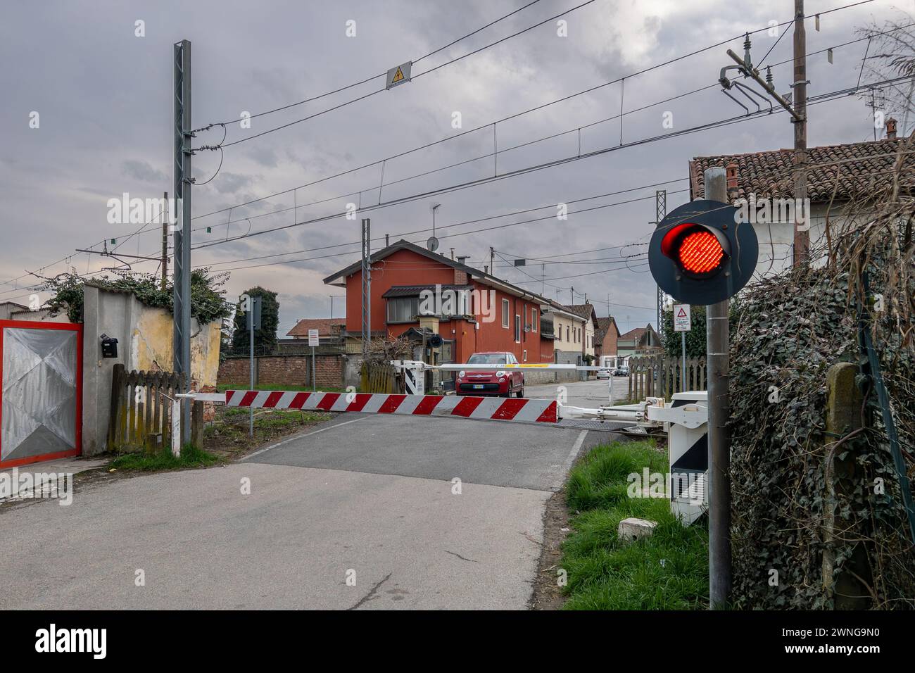 Sommariva del Bosco, Italia - 02 marzo 2024: Passaggio a livello chiuso con semaforo rosso sulla linea ferroviaria SFM4 Alba - Torino - caselle Airport Foto Stock