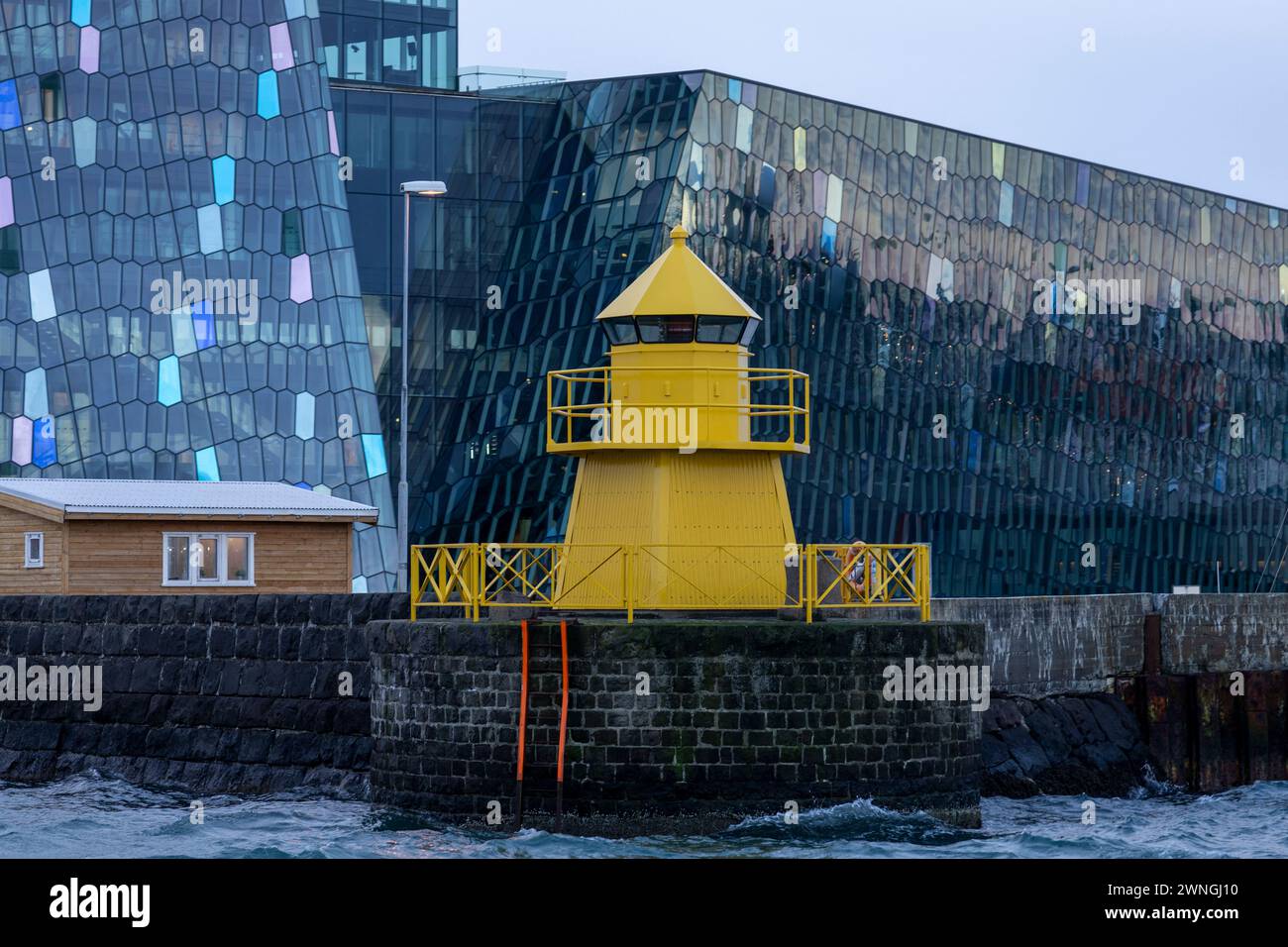 Harpa di Reykjavik e vista del faro giallo dalla baia del porto Foto Stock