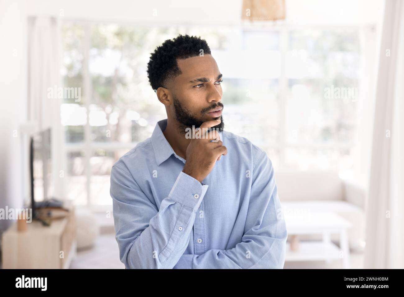 Serio pensivo attraente giovane uomo africano ritratto al coperto Foto Stock