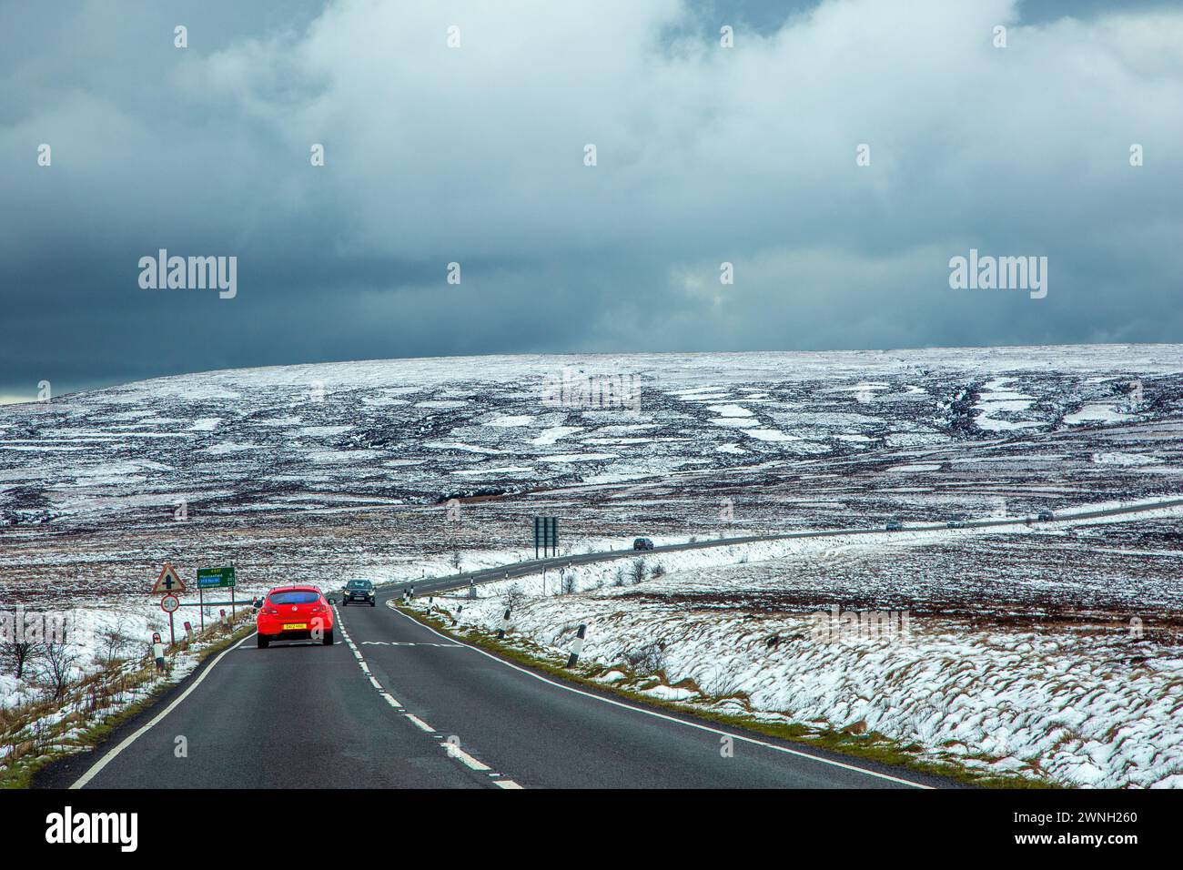 Red cr percorre la A537 Macclesfield fino a Buxton Road attraverso la neve coperta Axe Edge Moor sul Cheshire Derbyshire Border Peak District Foto Stock