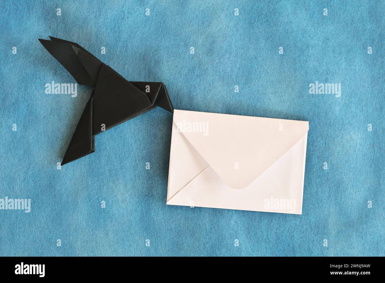 Origami in carta nero corvino con busta lettera bianca. E-mail, messaggi, corriere e consegna lettere. Foto Stock