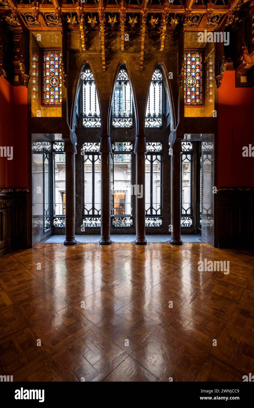 Sala visitabile del palazzo Palau Güell, con uno spettacolare soffitto in legno e finestre con archi parabolici e colonne (Barcellona, Catalogna, Spagna) Foto Stock