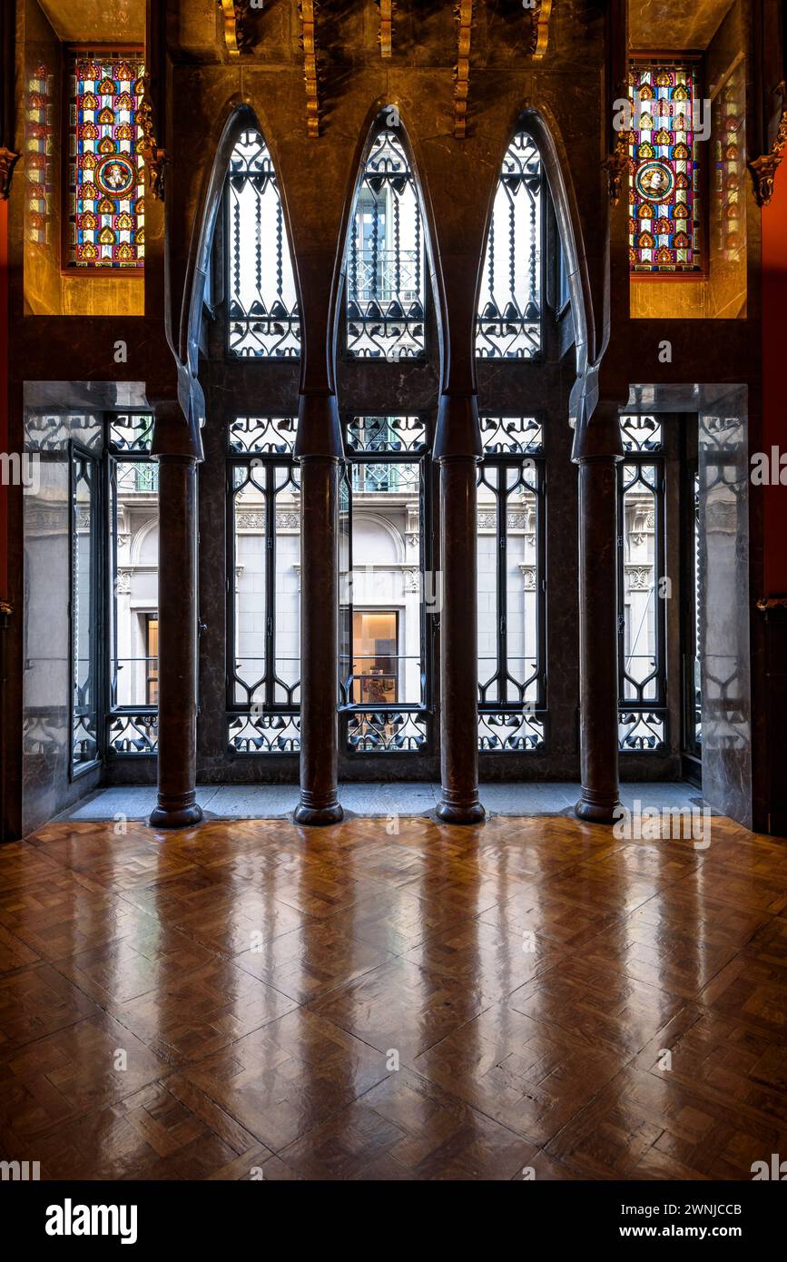 Sala visitabile del palazzo Palau Güell, con uno spettacolare soffitto in legno e finestre con archi parabolici e colonne (Barcellona, Catalogna, Spagna) Foto Stock