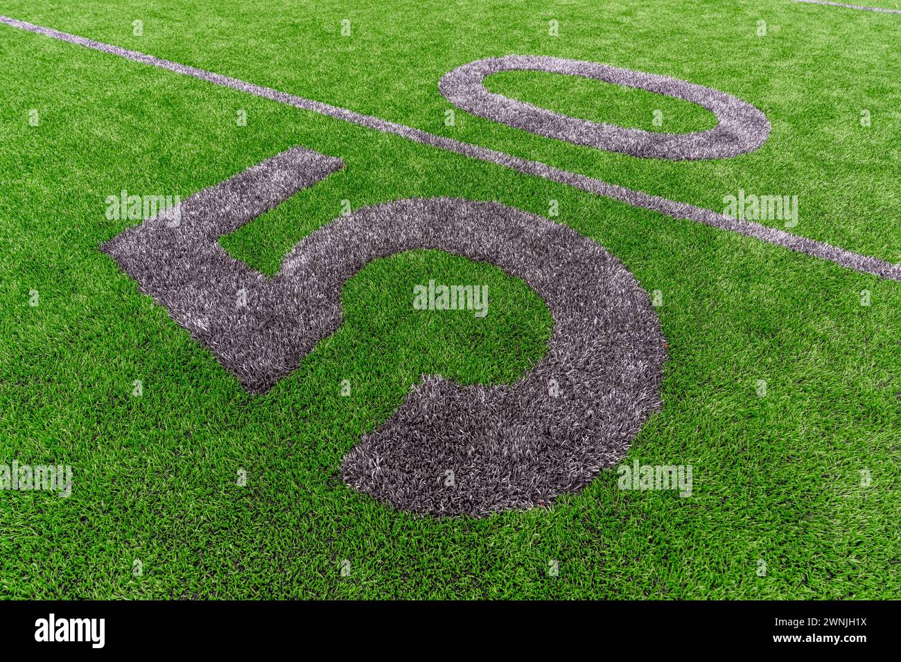 Calcio sintetico in erba da 50 yard e numeri a blocco in grigio. Le marcature per il campo da calcio sono meno evidenti e installate in campo esterno Foto Stock