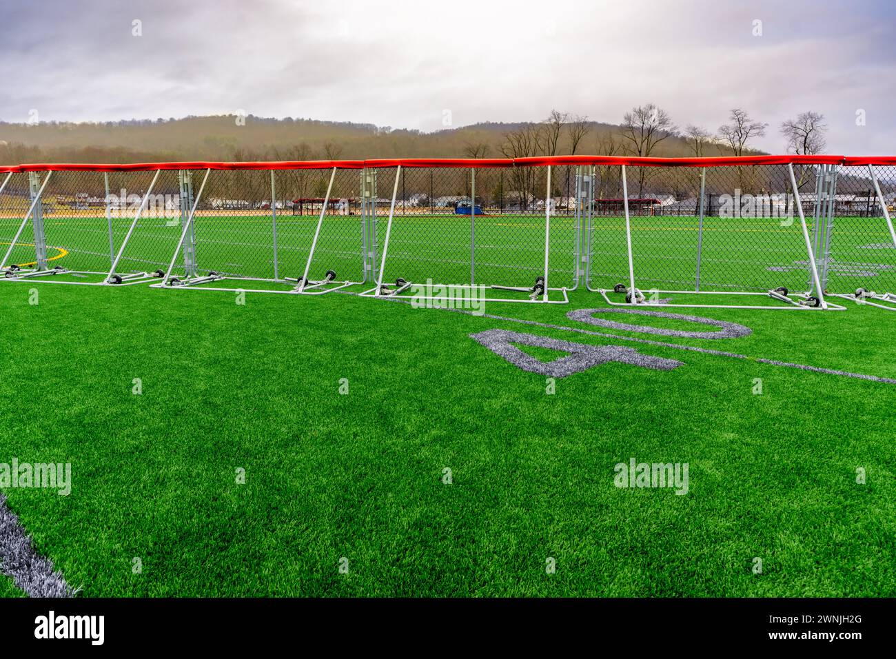 Calcio sintetico in erba da 40 yard e numeri a blocco in grigio con recinzione esterna portatile per baseball. Foto Stock