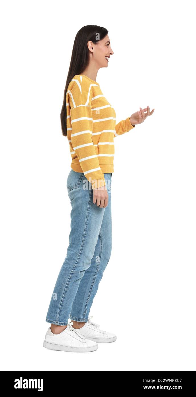 Donna felice in jeans e maglione su sfondo bianco Foto Stock