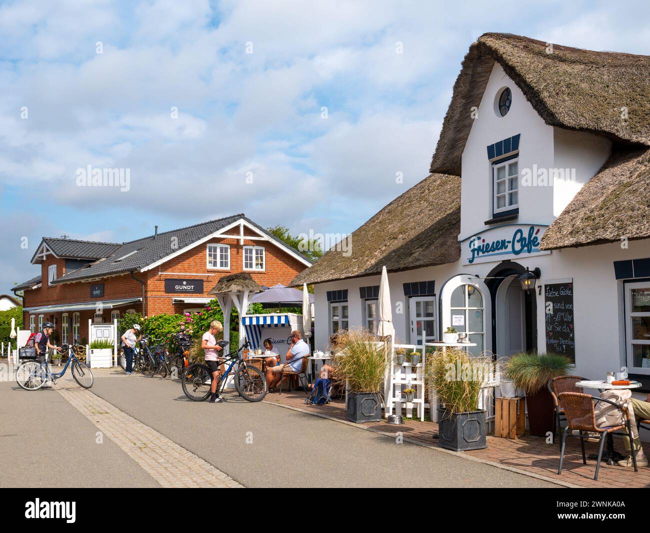 Strada con caffetterie all'aperto nella città vecchia di Nebel, l'isola di Amrum, la Frisia settentrionale, Schleswig-Holstein, Germania Foto Stock
