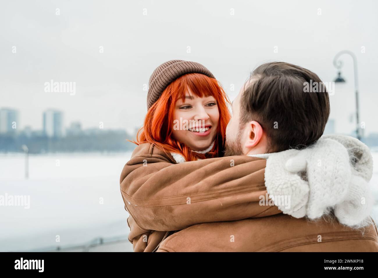 Amore romantico soggiorno di coppia. Brutale uomo barbuto, brillante ragazza dai capelli rossi nel parco invernale. Appuntamento romantico, baci, abbracci. Camminare, divertirsi. Foto Stock