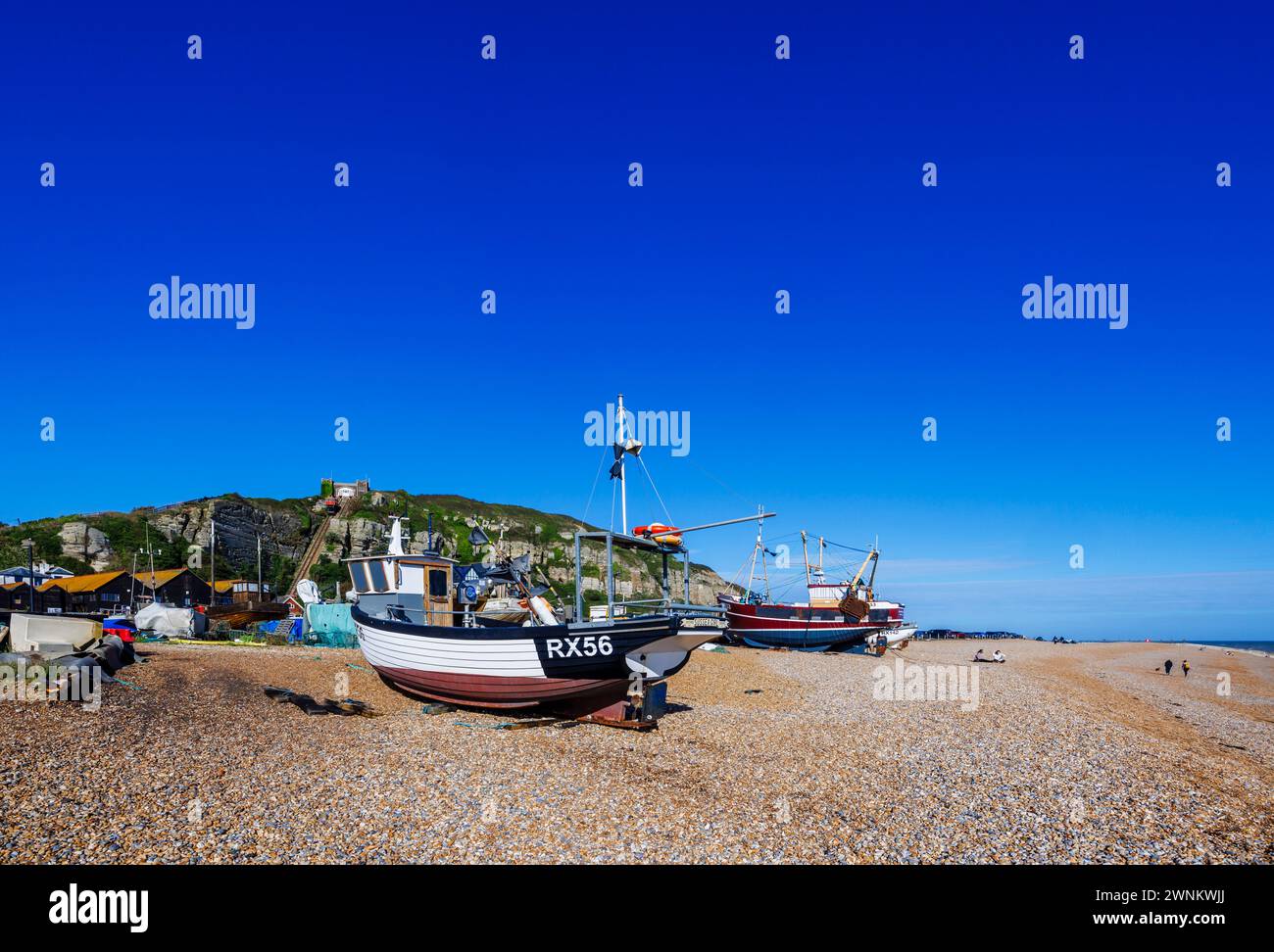 Piccole barche da pesca in legno tradizionali e spiaggiate sulla spiaggia di Hastings, East Sussex, Inghilterra Foto Stock