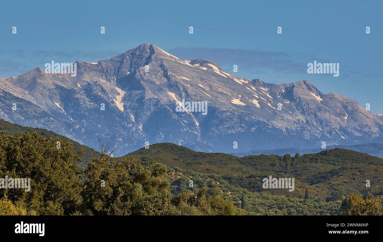 Una maestosa vetta innevata si erge sopra le verdi foreste, i monti Taygetos, la penisola di mani, il Peloponneso, la Grecia Foto Stock