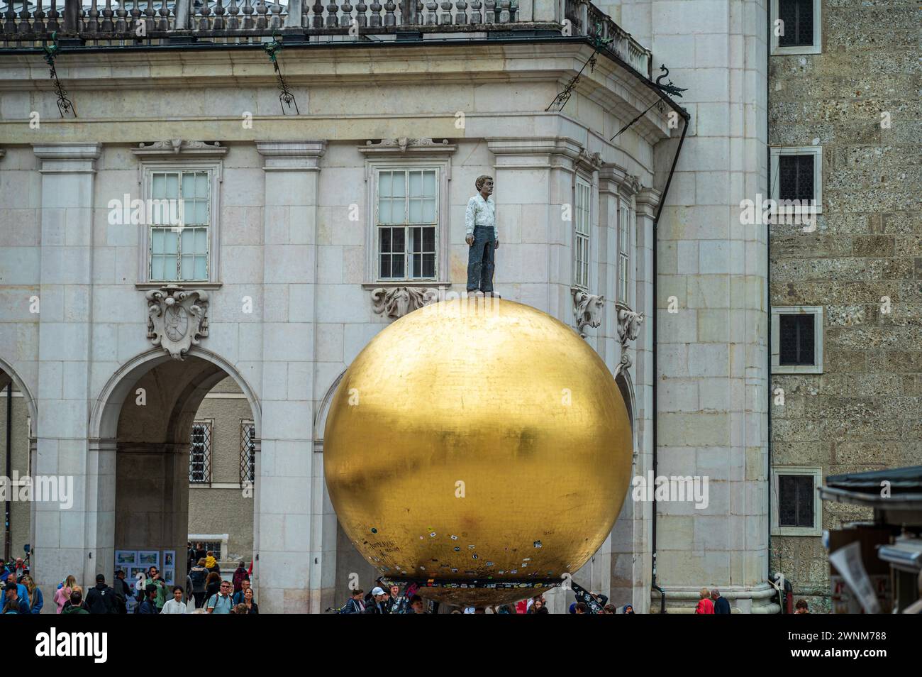 Stravagante scultura a sfera dorata con una figura umana su una facciata di un edificio, Salisburgo, Austria Foto Stock