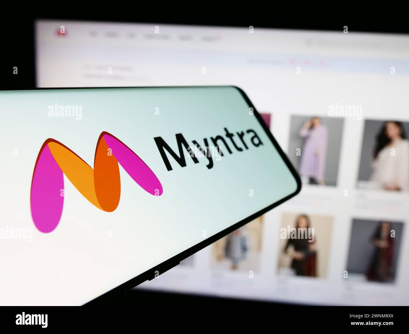 Telefono cellulare con logo della società indiana di e-commerce Myntra Designs Pvt. Ltd. Di fronte al sito Web aziendale. Mettere a fuoco la parte centrale sinistra del display del telefono. Foto Stock