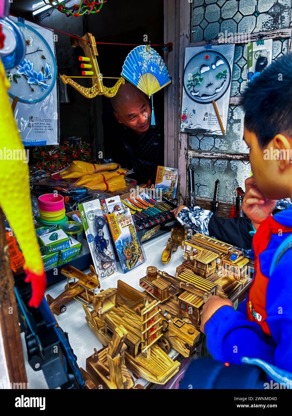 Suzhou, Cina, vecchio uomo cinese, vendita di giocattoli in legno, al bambino in un negozio vintage, città storica, vintage estivo per bambini, economia comunista cinese, Foto Stock