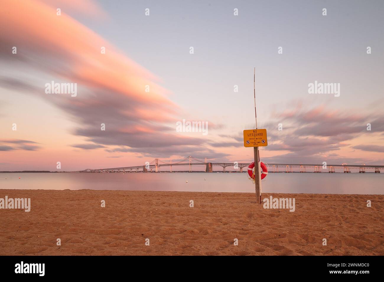 Onde calme si infrangono sulle rive di Sandy Point al tramonto. Foto Stock