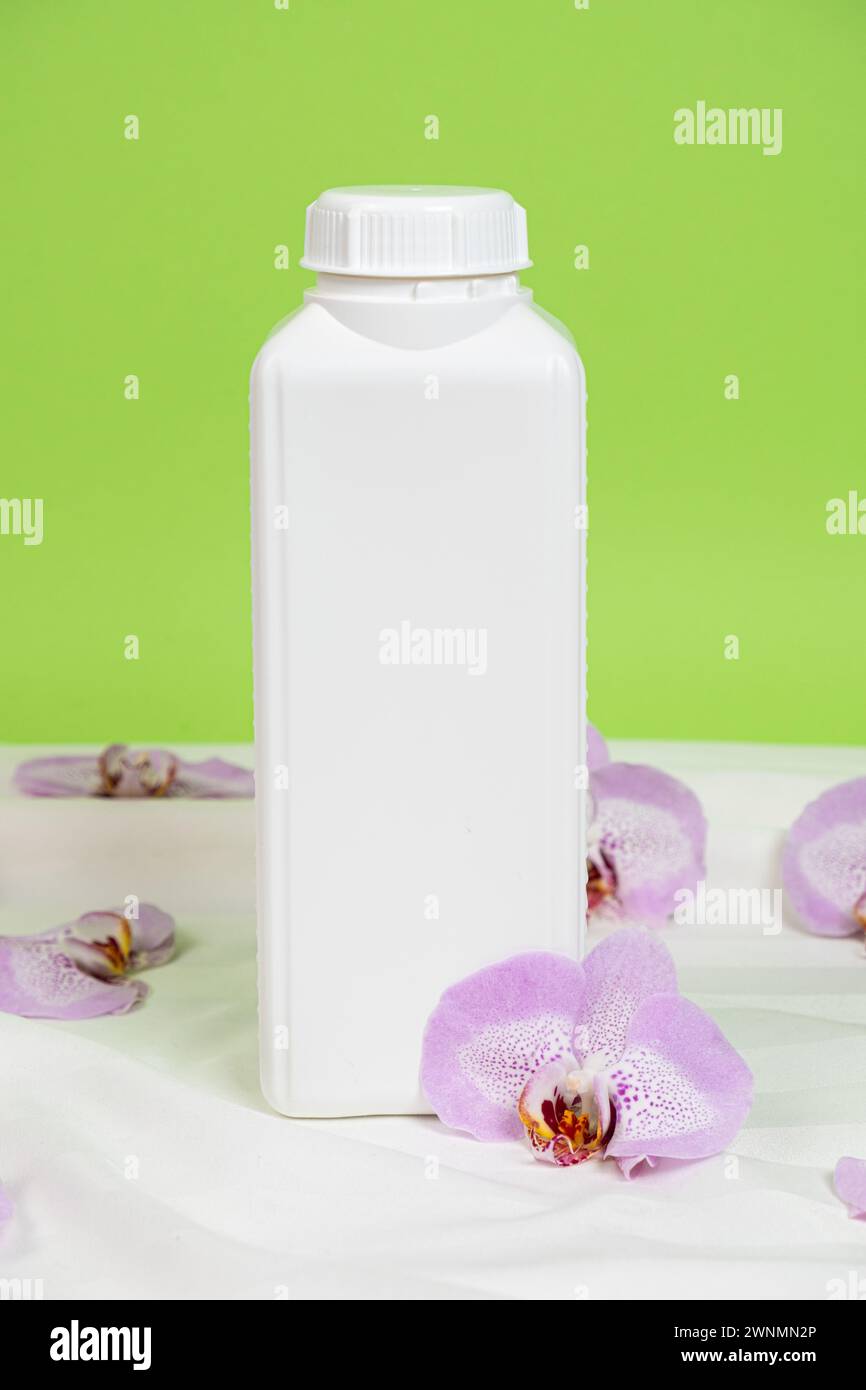 Bottiglia di plastica bianca grande per prodotti chimici domestici su sfondo verde, spazio per testo. Foto Stock