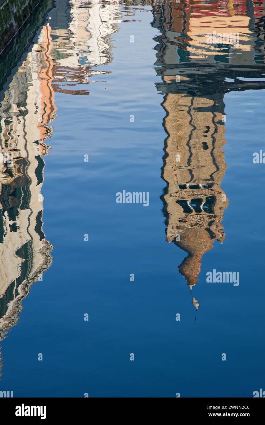 Riflesso di un Campanile sulle acque blu di un canale veneziano Foto Stock