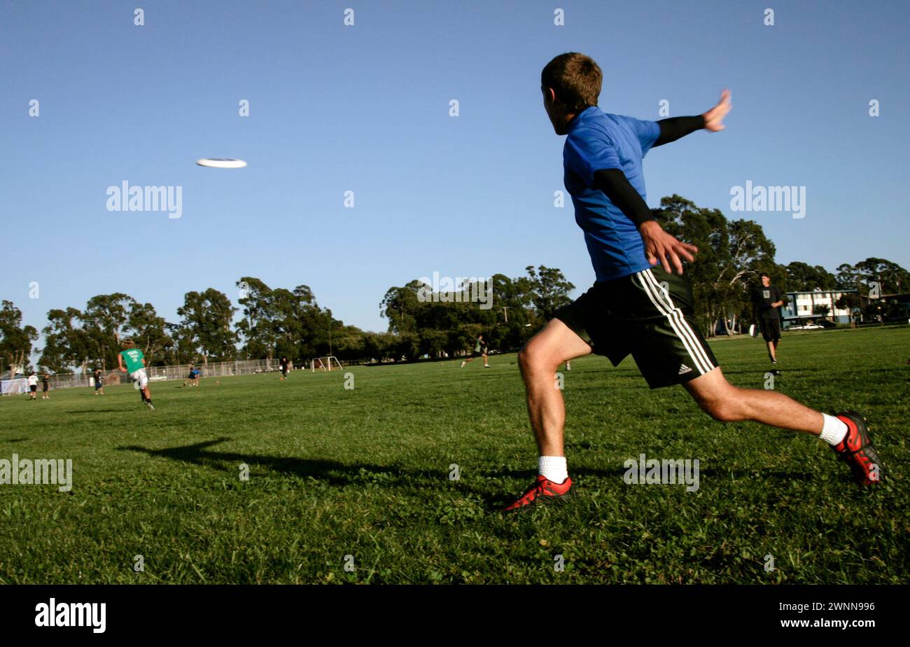 I membri del team Ultimate Frisbee dimostrano la loro abilità saltando presso l'Università della California, Santa Barbara. I giocatori spesso eseguono acrobazie Foto Stock