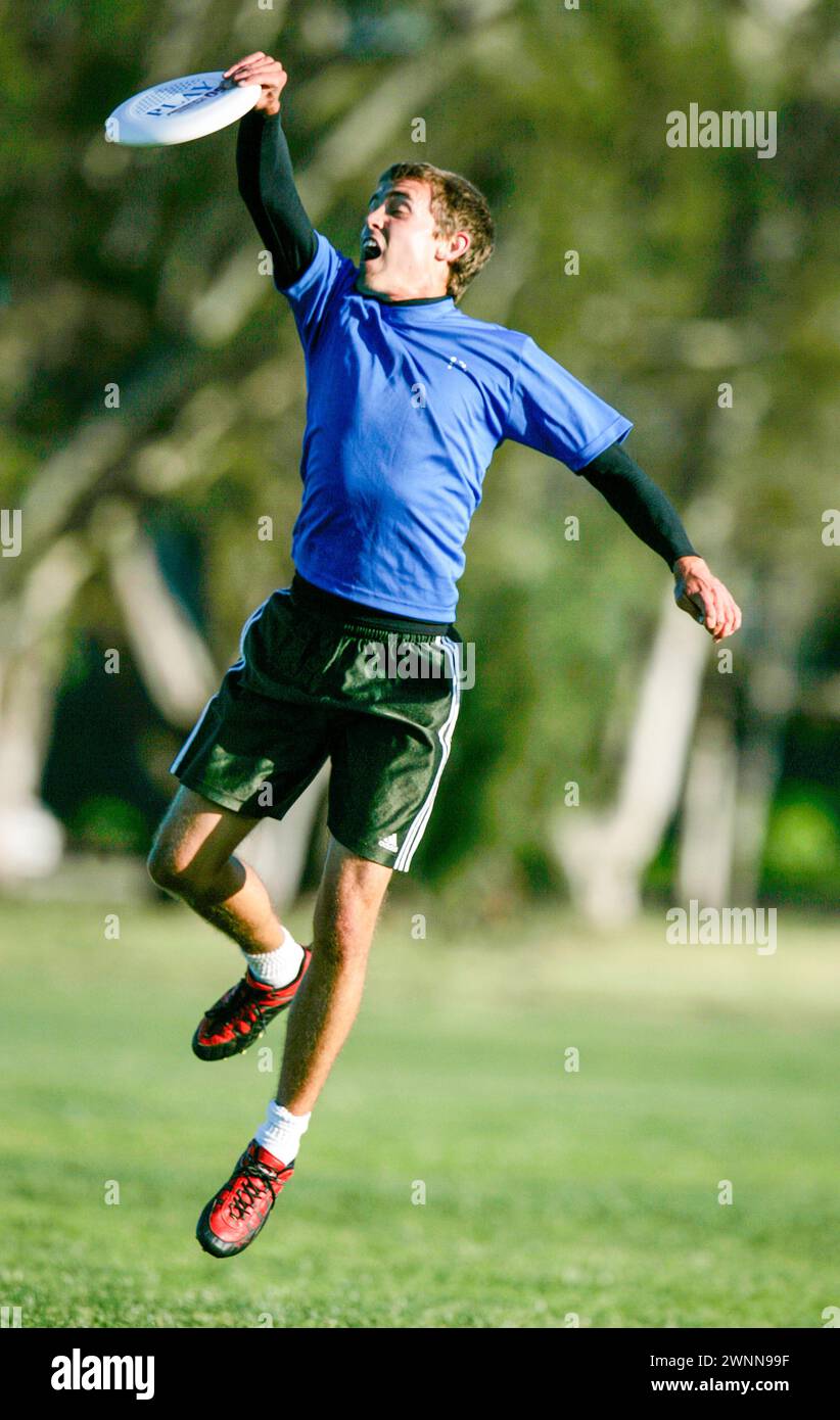 I membri del team Ultimate Frisbee dimostrano la loro abilità saltando presso l'Università della California, Santa Barbara. I giocatori spesso eseguono acrobazie Foto Stock
